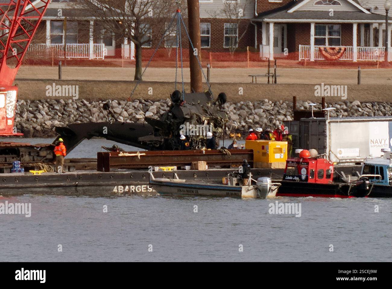 Salvage crews pull up a part of a Black Hawk helicopter near the site ...