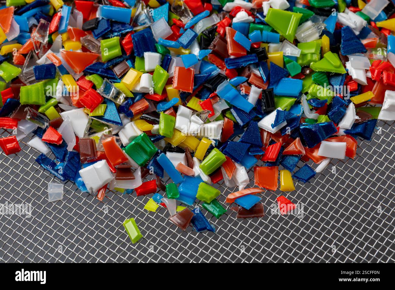 Small pieces of recycled plastic. Microplastics pollution, recycling and disposal concept. Stock Photo