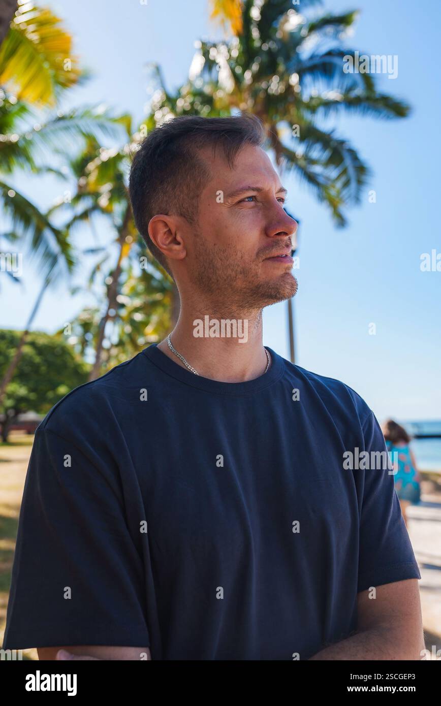Man Standing Among Palm Trees with Ocean and Beach in Background Stock ...