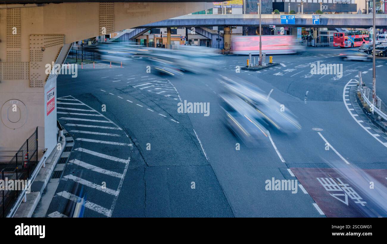 Late afternoon traffic in motion at the main intersection near Ueno Station in Tokyo’s Taito Ward, as viewed from the pedestrian overpass. Stock Photo