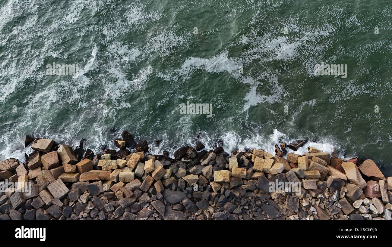 Aerial top view of sea waves hitting rocks on the beach in Swakopmund ...