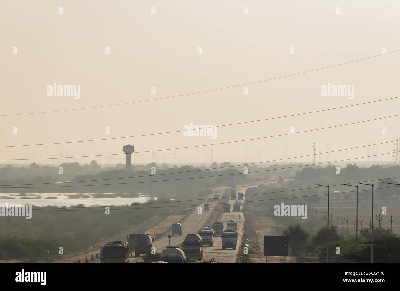 highway with traffic at hazy evening near city Stock Photo
