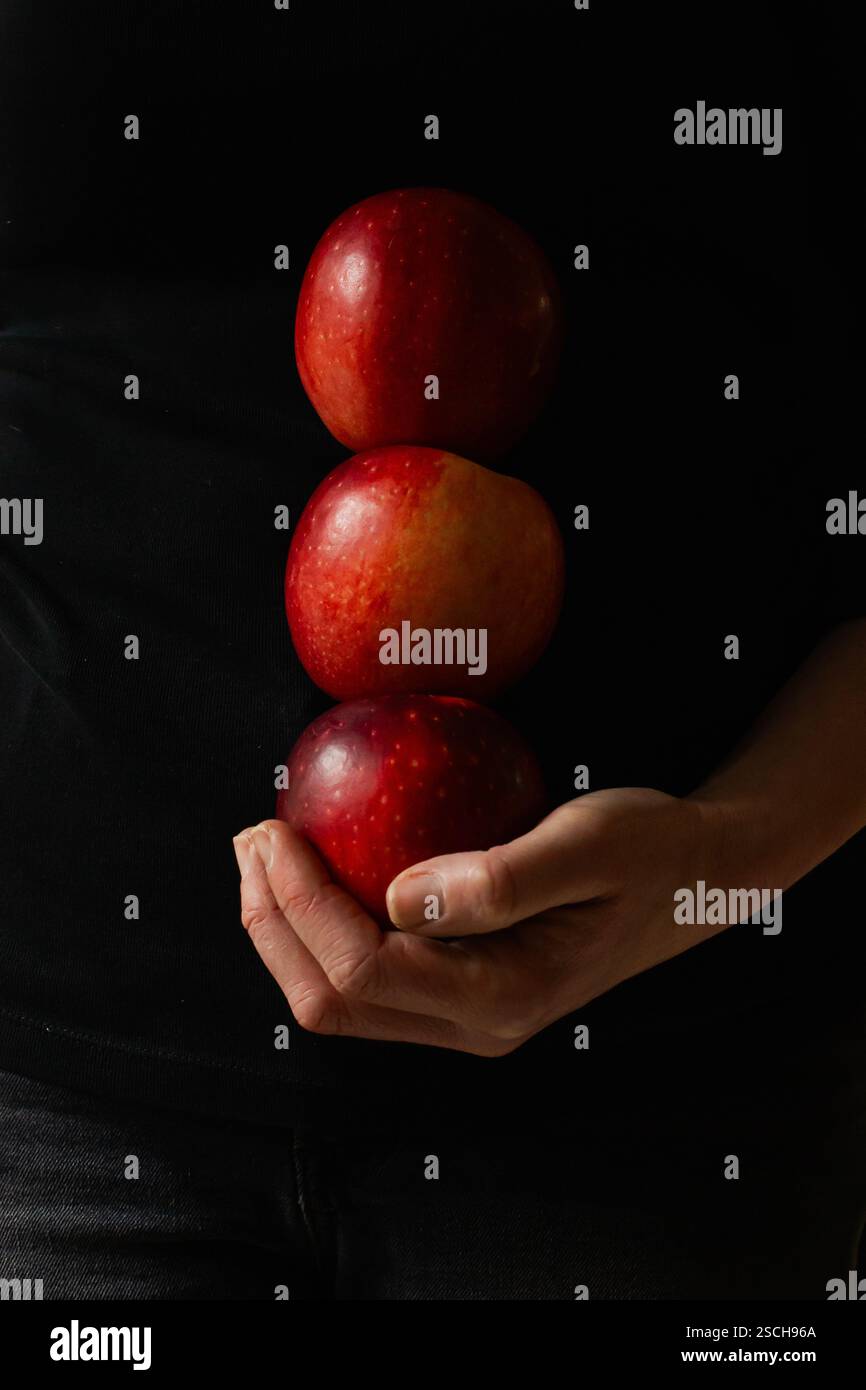 Hand holding three red apples Stock Photo - Alamy
