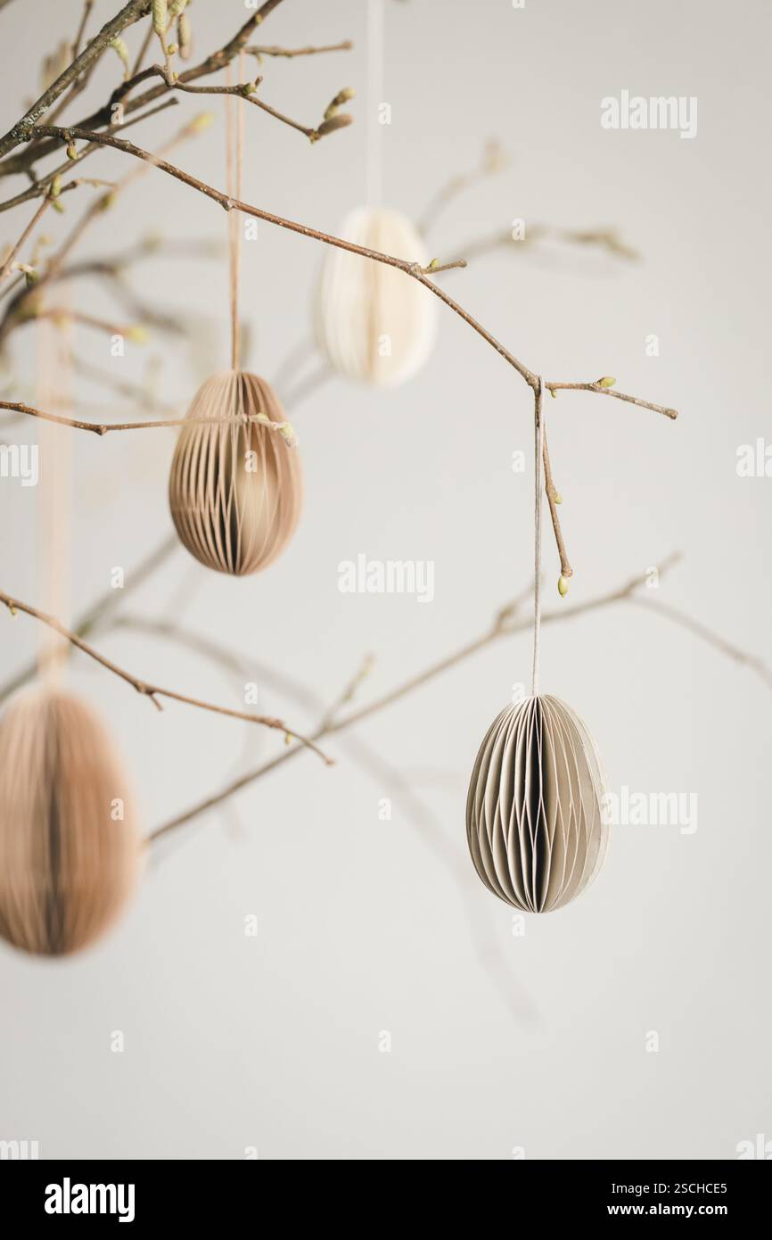 Easter paper eggs hanging on branches. Scandinavian-style Easter decorations. Stock Photo