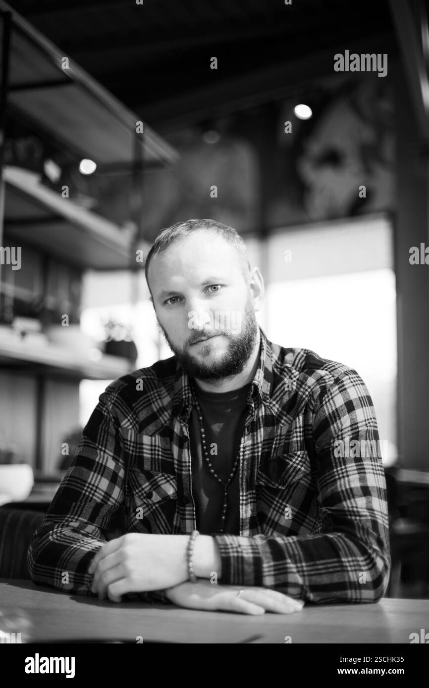 A nice and stylish man sits in a cafe, thoughtful. Stock Photo