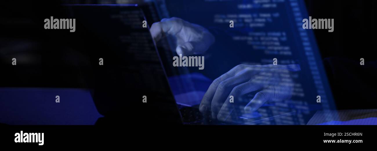 Modern workspace with blue virtual interface displaying fictional programming text. Hands typing on laptop, illustrating cybersecurity Stock Photo