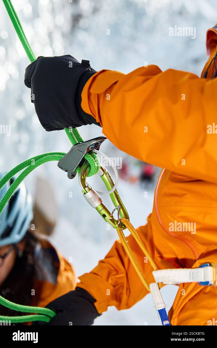 Climbing belaying. ICE Climber in yellow jacket insures his friend by ...