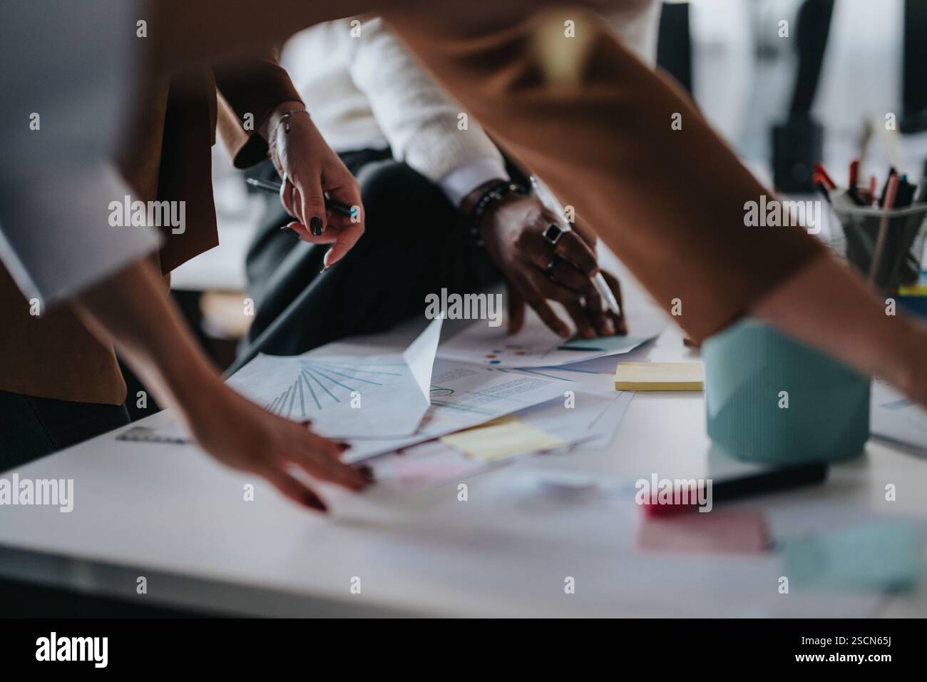 Business professionals collaborating over documents in modern office environment Stock Photo