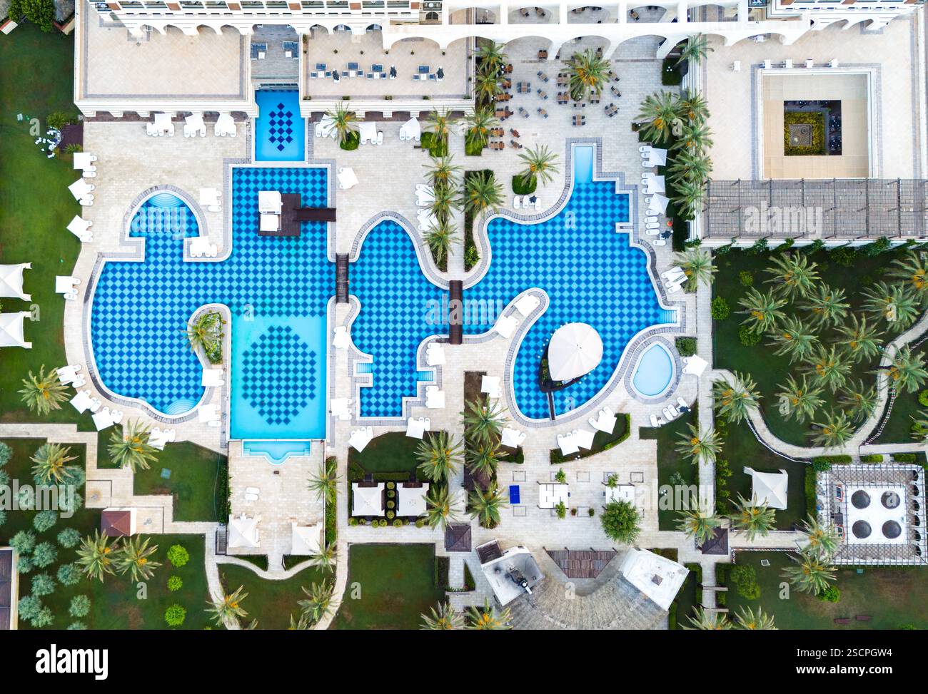 Aerial view of a luxury resort with a uniquely designed pool, lush ...