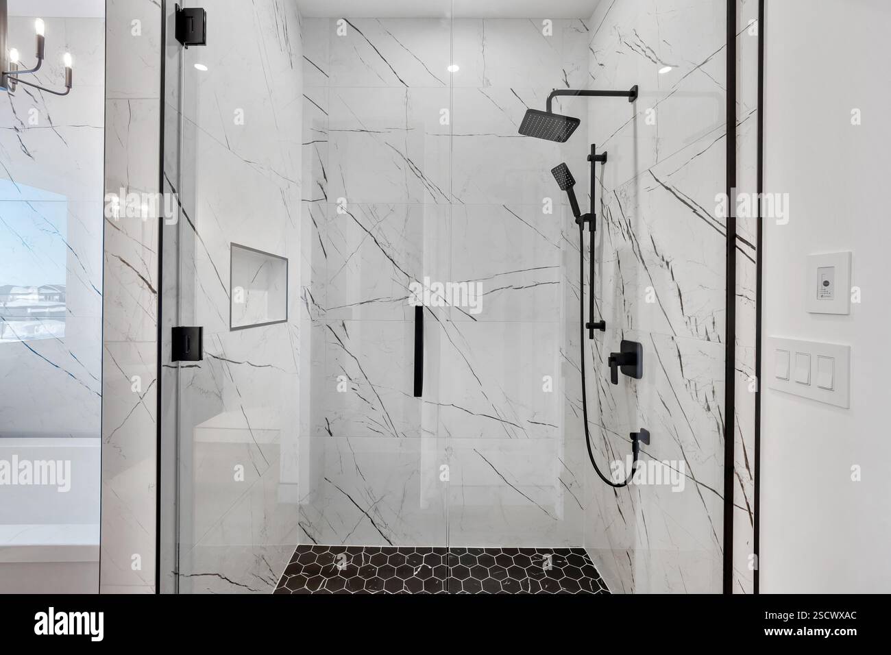 A bathroom with a marble floor and a black and white shower Stock Photo ...