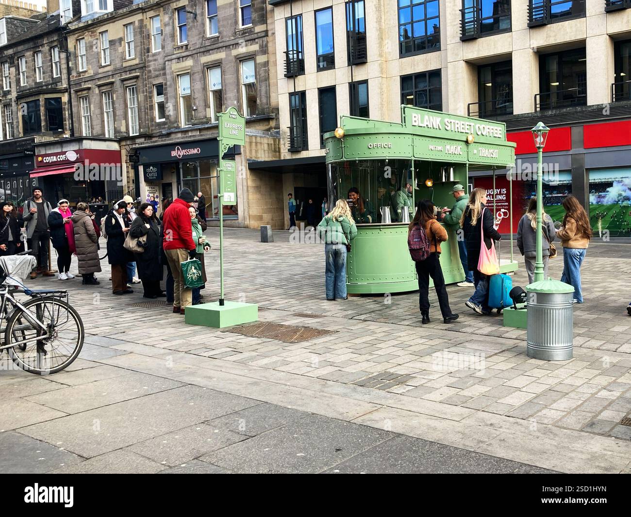 Customers queuing for free tasters of the Blank Street Coffee viral coffee on Castle Street, promoting the recent opening of 2 outlets in Edinburgh - Smartphone Captured Stock Image