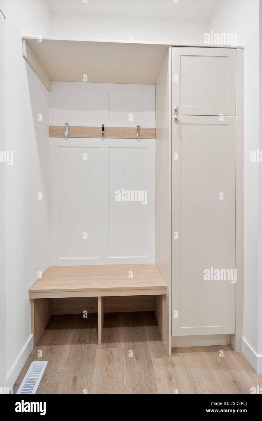 Small white room with a bench and a cabinet. The bench is wooden and ...