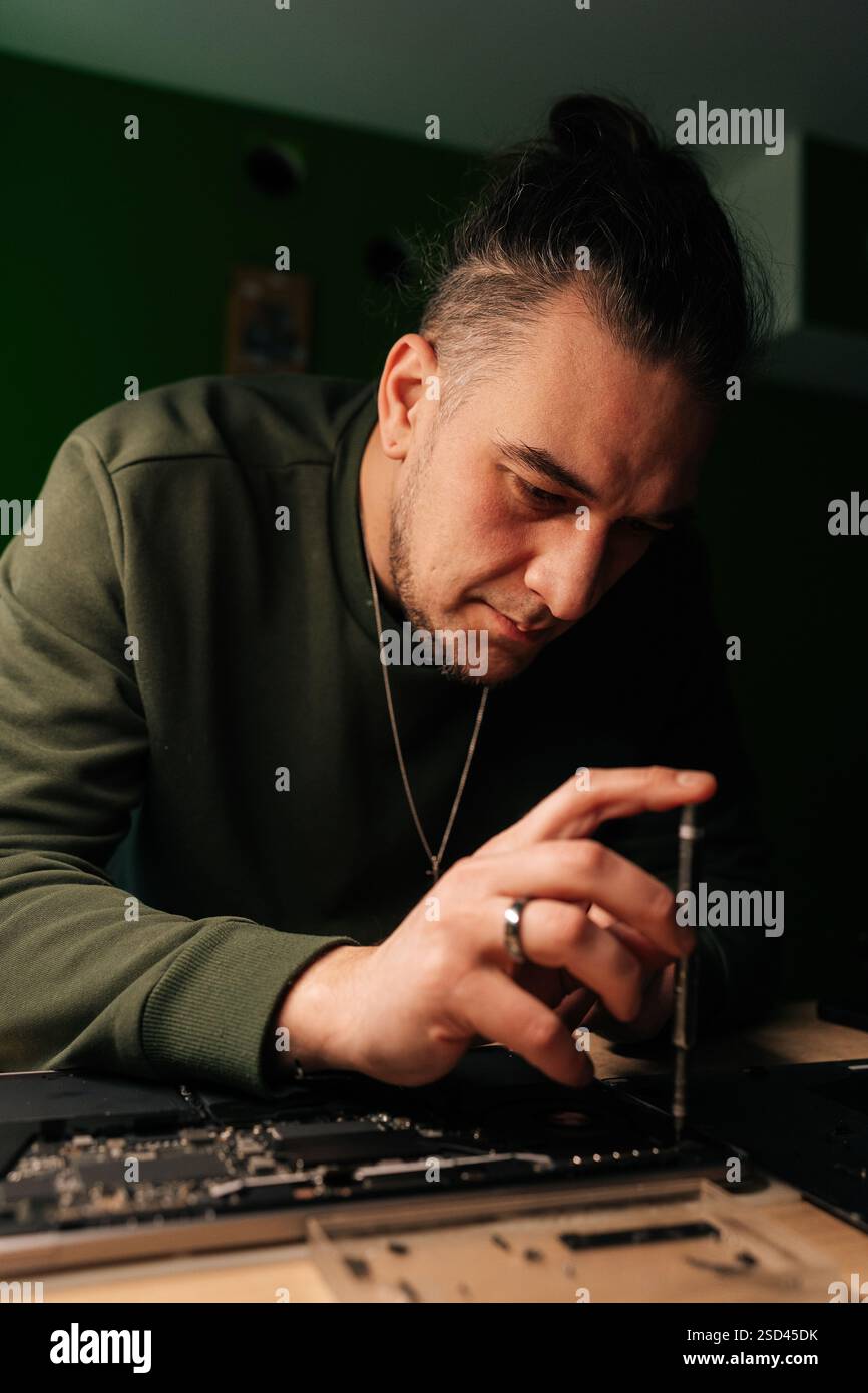 Vertical Portrait Of Electronic Technician Using Screwdriver To