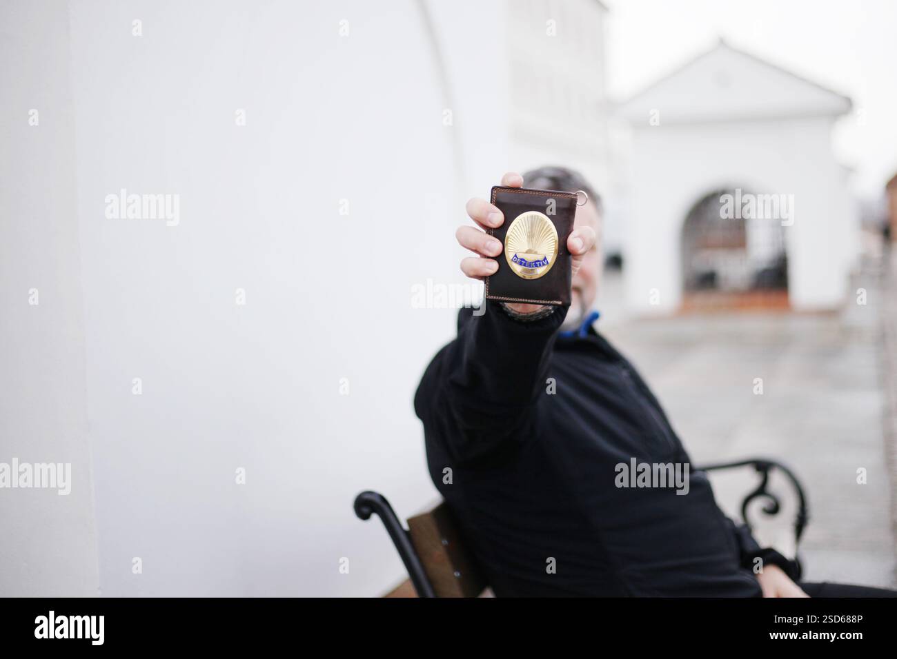 50-year-old man shows a Detective badge, focus on the badge Stock Photo