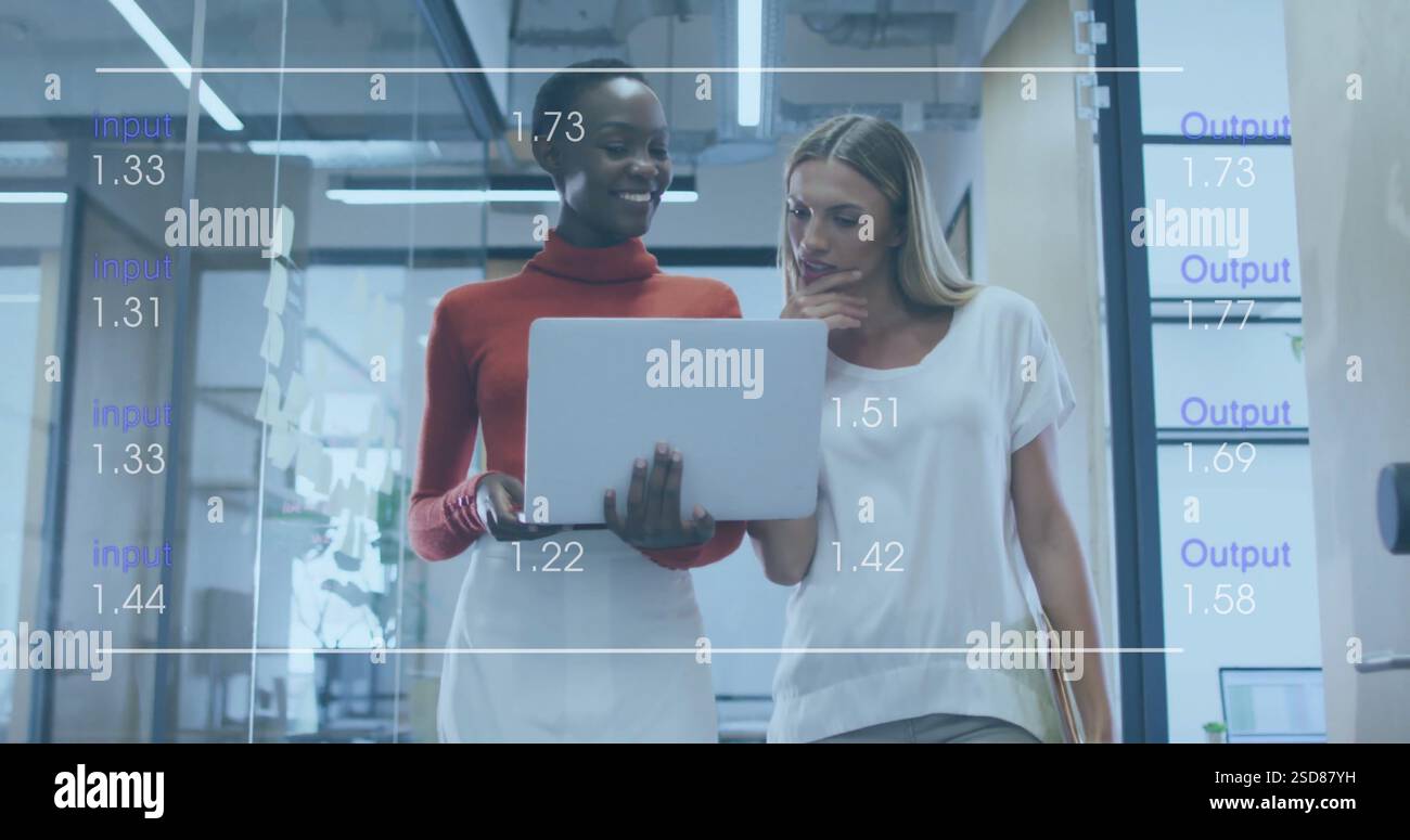 Two women collaborating in modern office, analyzing data on laptop screen Stock Photo