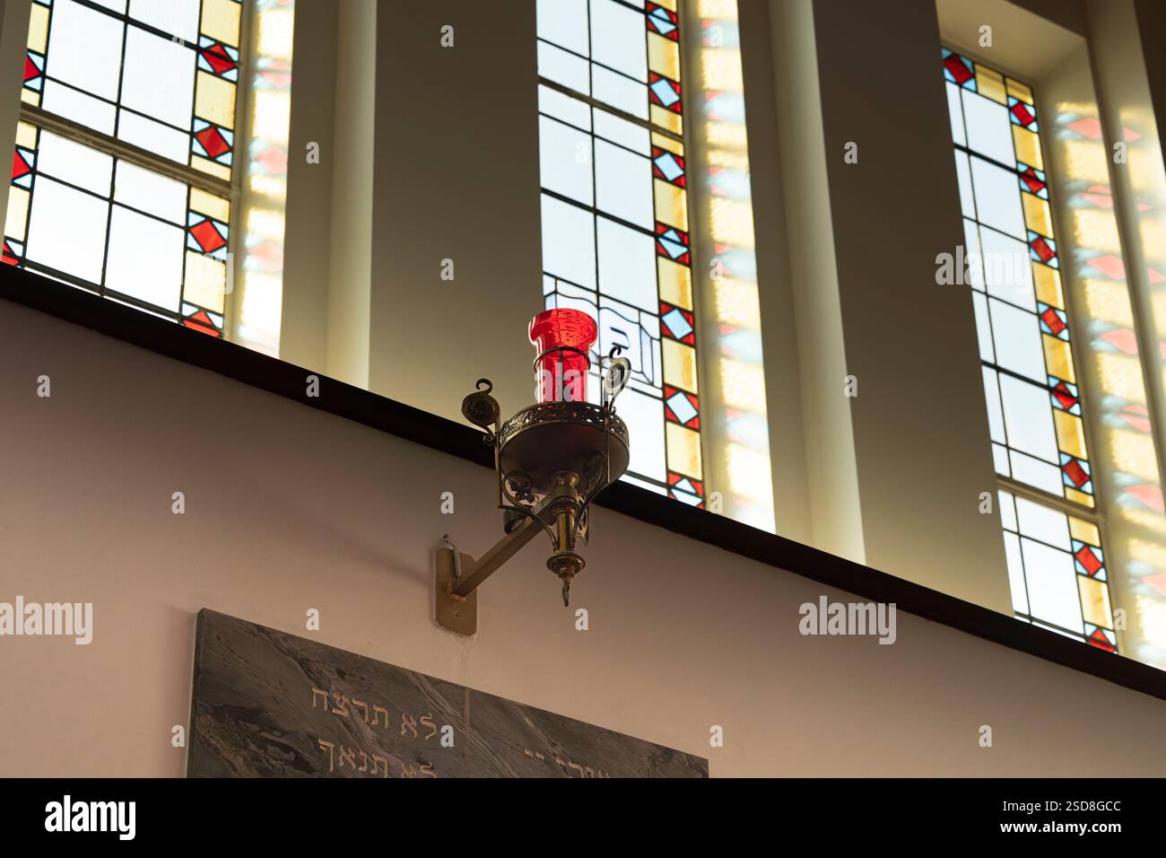 Red glass menorah in the  synagogue.  Jewish religious artifact. Stock Photo