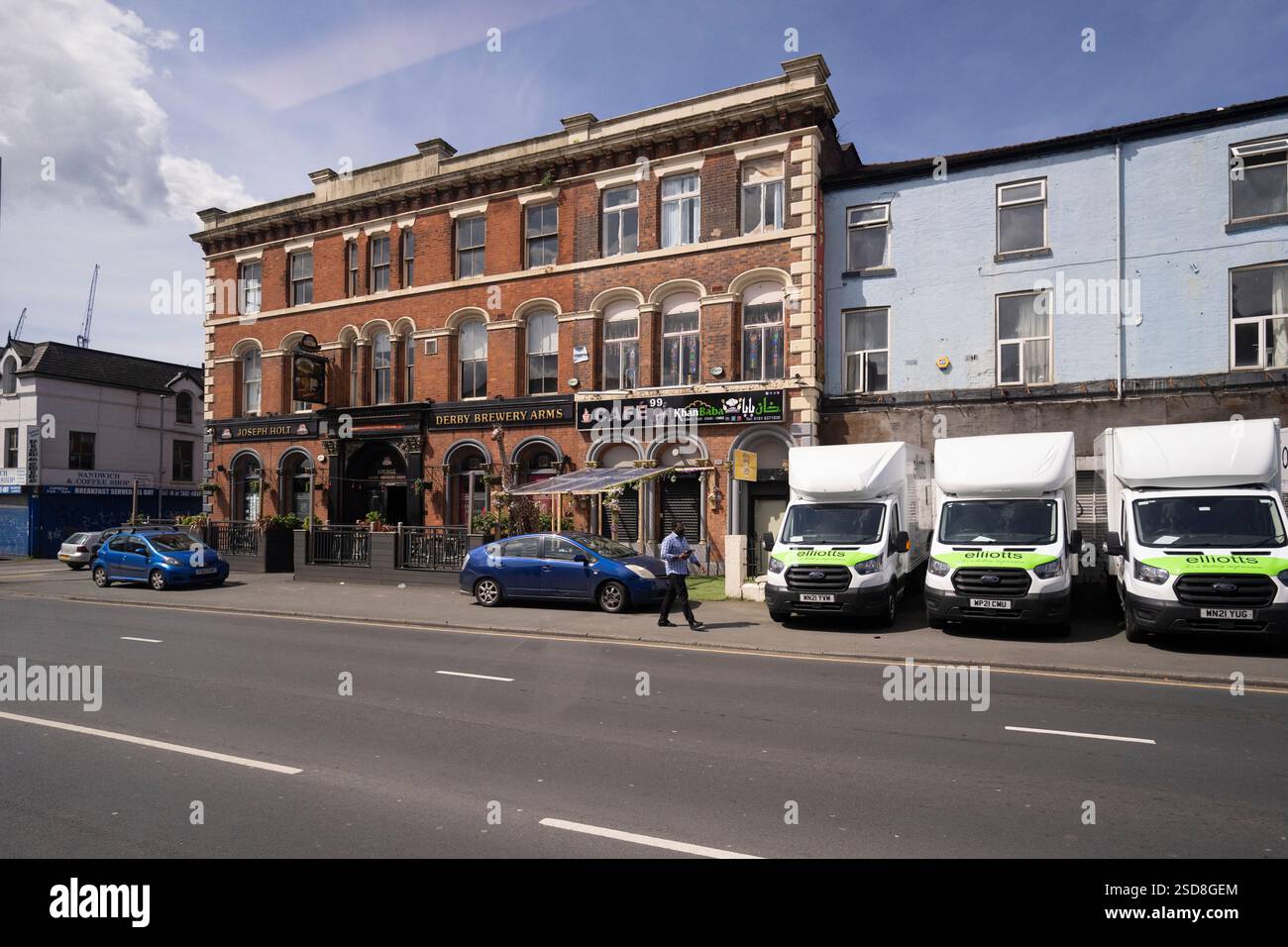 Delivery vans outside the Derby Brewery Arms pub.  A pedestrian walks by. Stock Photo