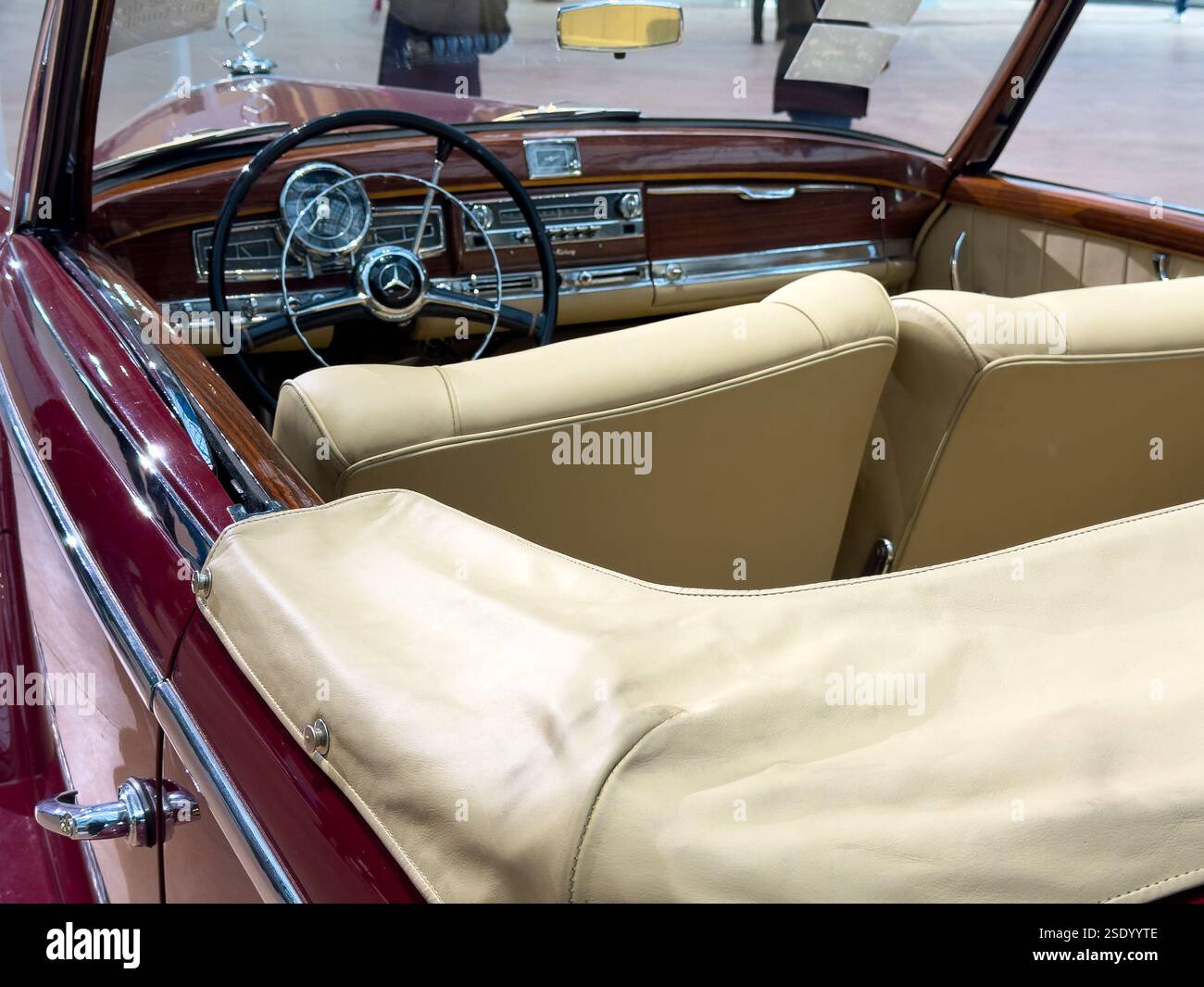 Classic convertible showcases timeless elegance in a modern exhibition hall Stock Photo