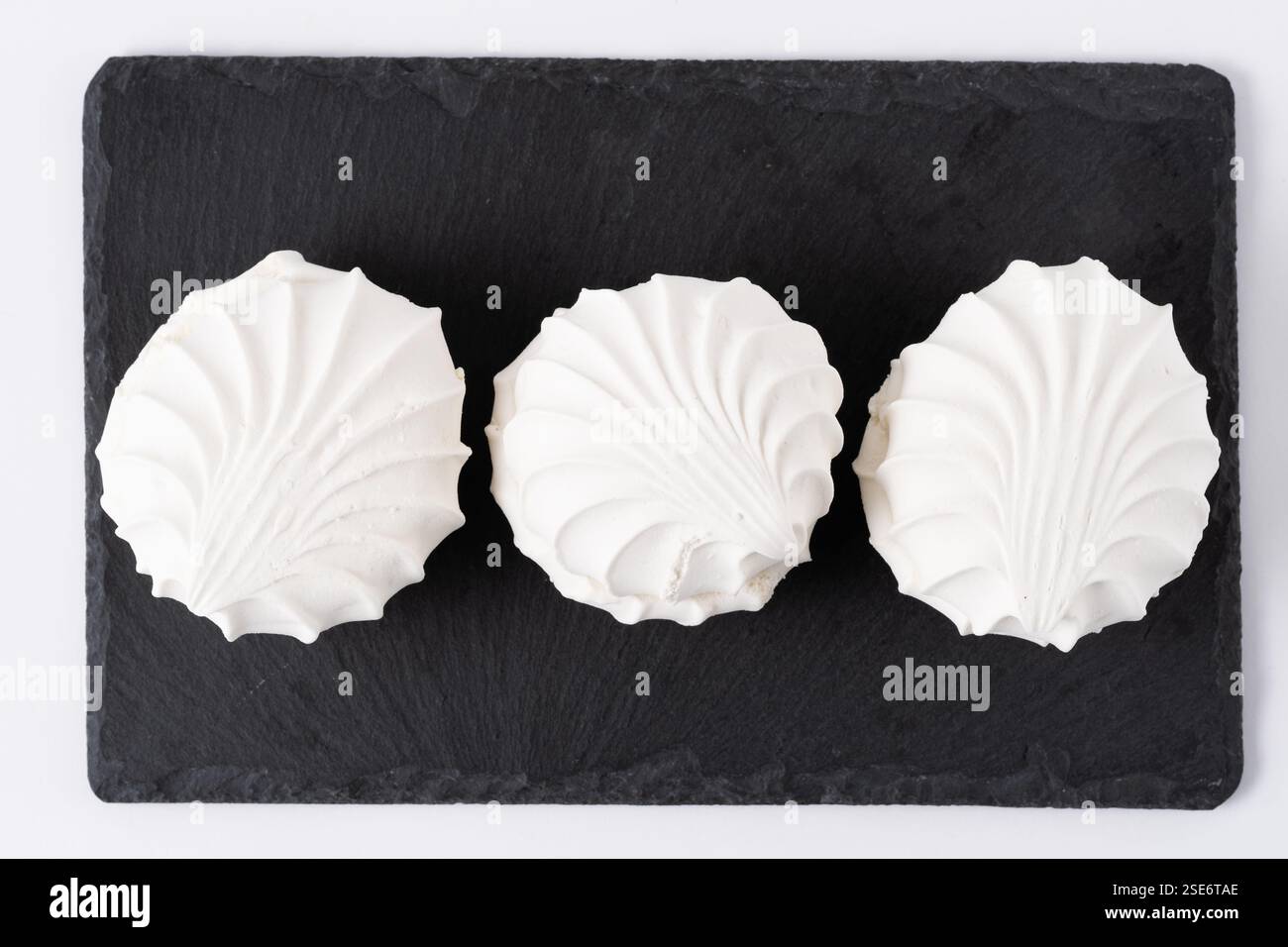 Three white zephyr on black slate plate Stock Photo