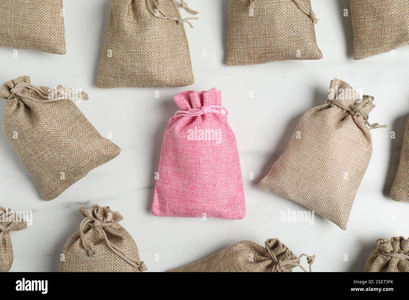 Different burlap bags on white marble table, flat lay Stock Photo