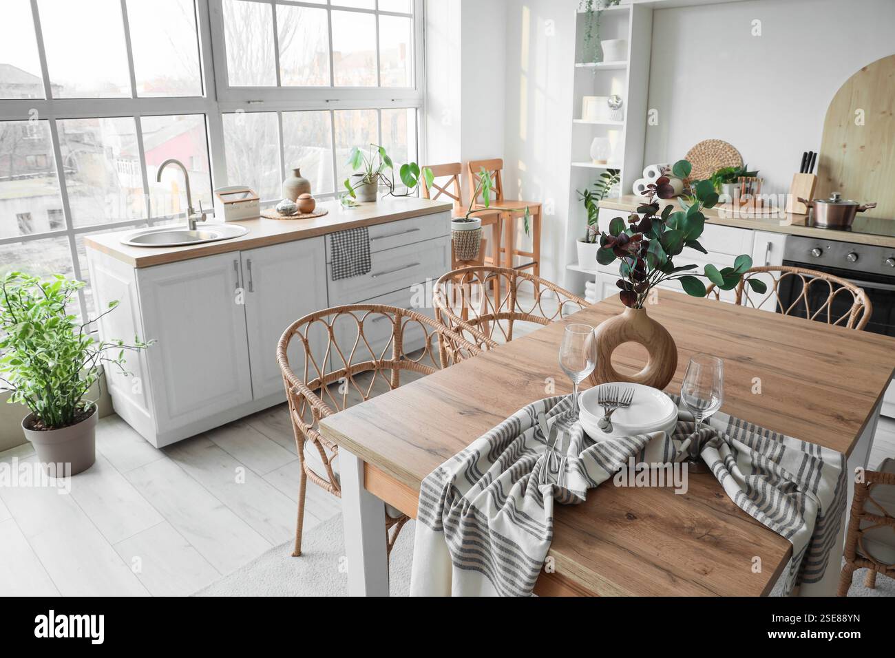 Interior of light kitchen with dining table, counters and shelf unit ...