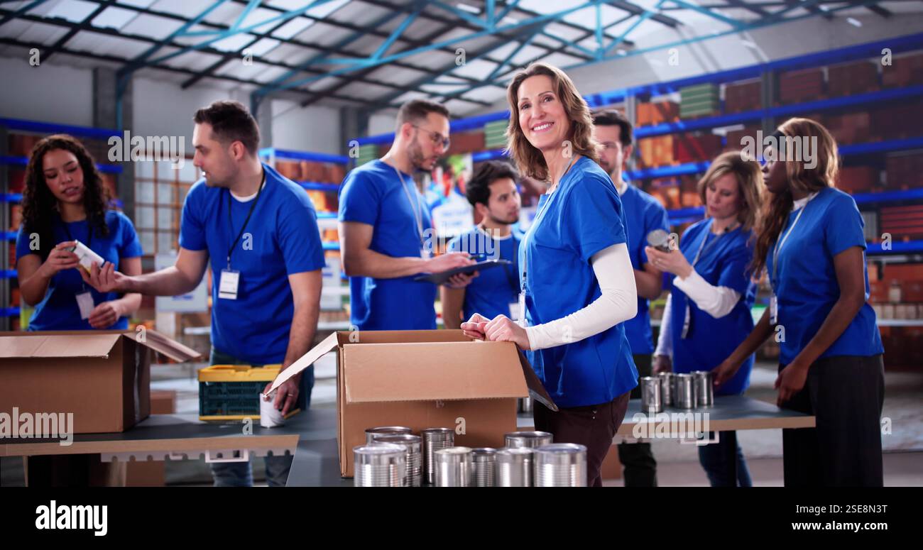 Diverse charity team volunteers at foundation, donating food and clothes. Stock Photo