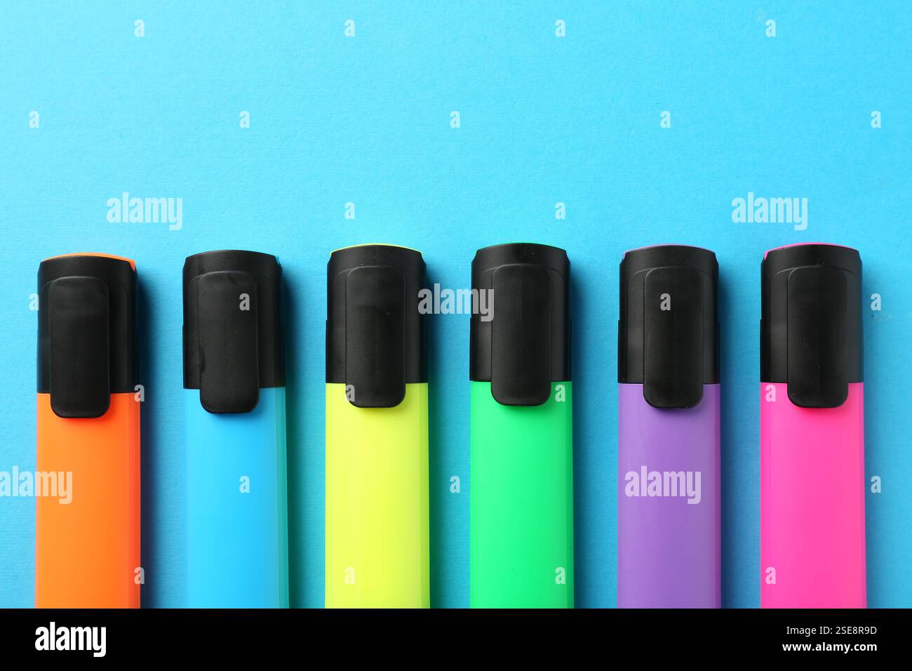 Bright highlighters on light blue background, flat lay Stock Photo