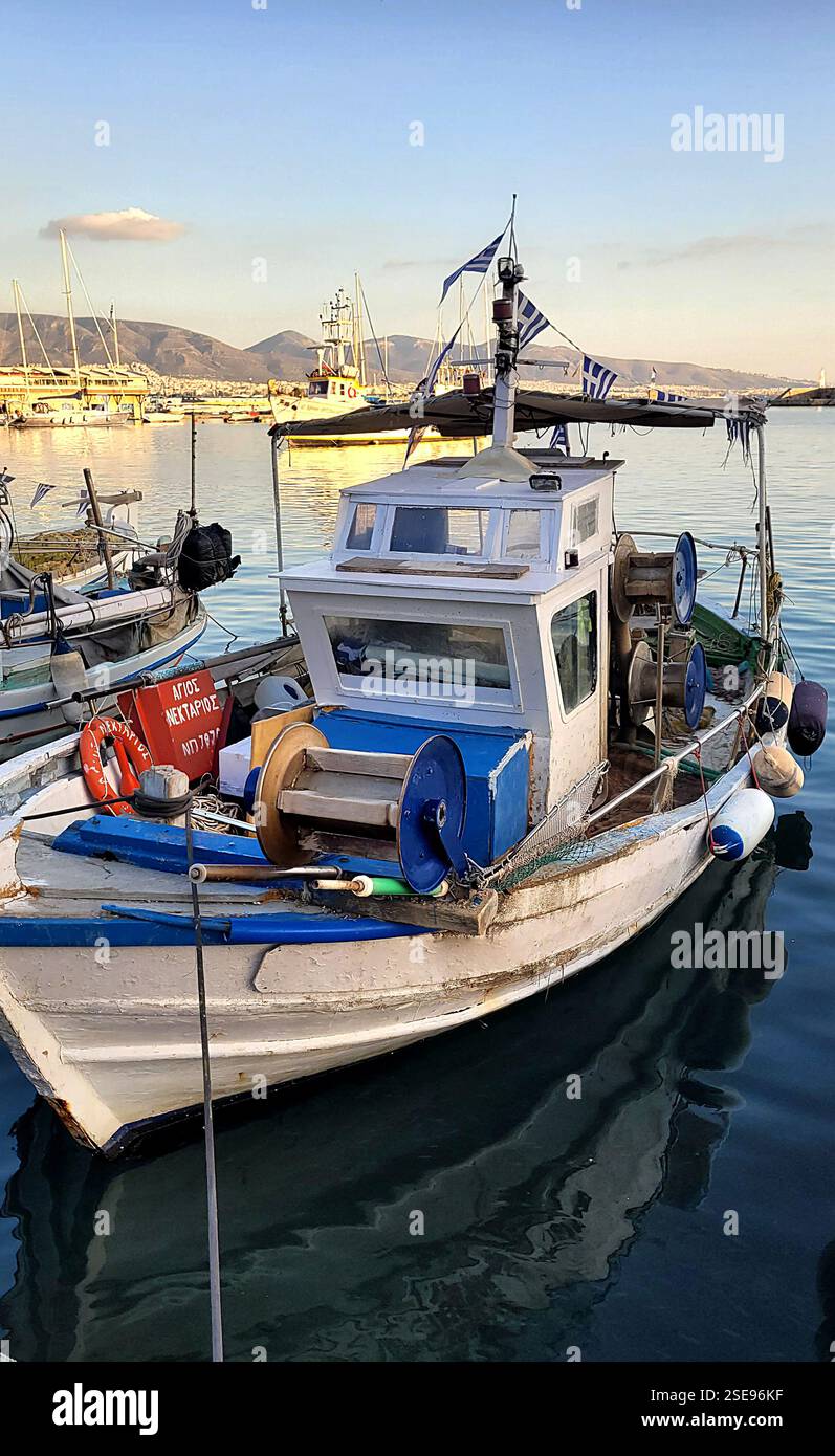 The image shows a fishing boat moored on calm water Stock Photo - Alamy