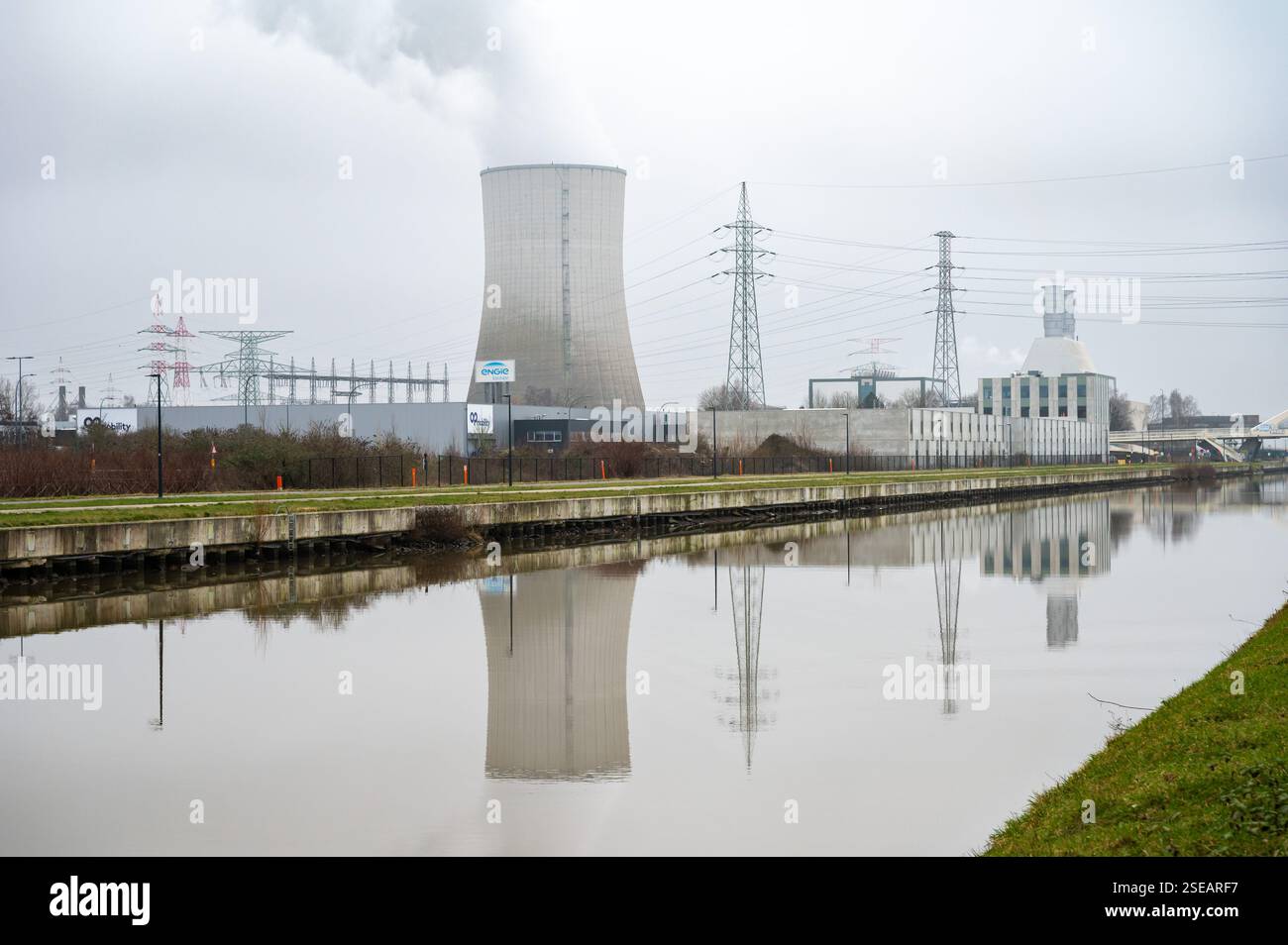 Engie power plant with cooling tower of Ruisbroek and high voltage  electricity poles reflecting in the canal, Anderlecht, Brussels, Belgium.  FEB 5, 20 Stock Photo - Alamy