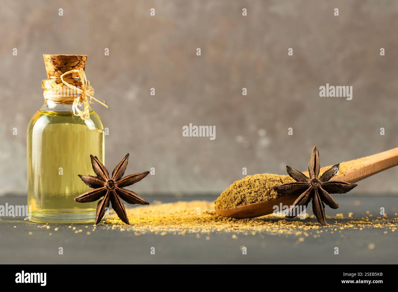 Glass bottle of anise essential oil with anise star and powder, spice oil concept, ( Pimpinella anisum ) Stock Photo