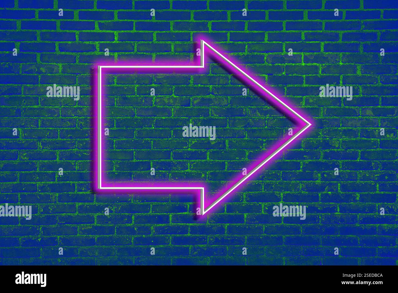 Pink neon arrow-shaped pointer on blue brick wall Stock Photo