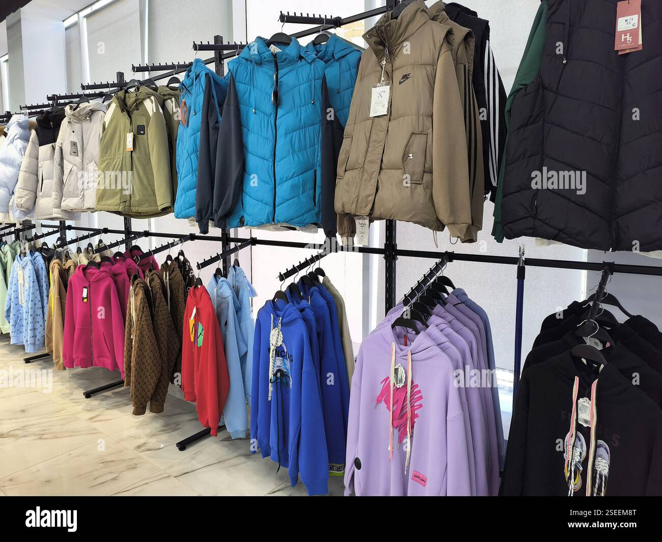 Colorful assortment of jackets and hoodies on display racks in clothing ...