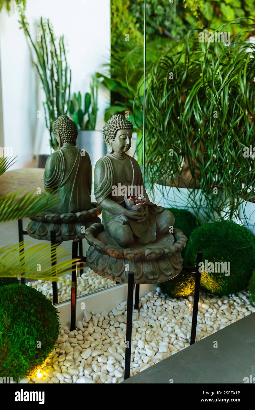 Zen-inspired home interior with Buddha statue and greenery Stock Photo ...