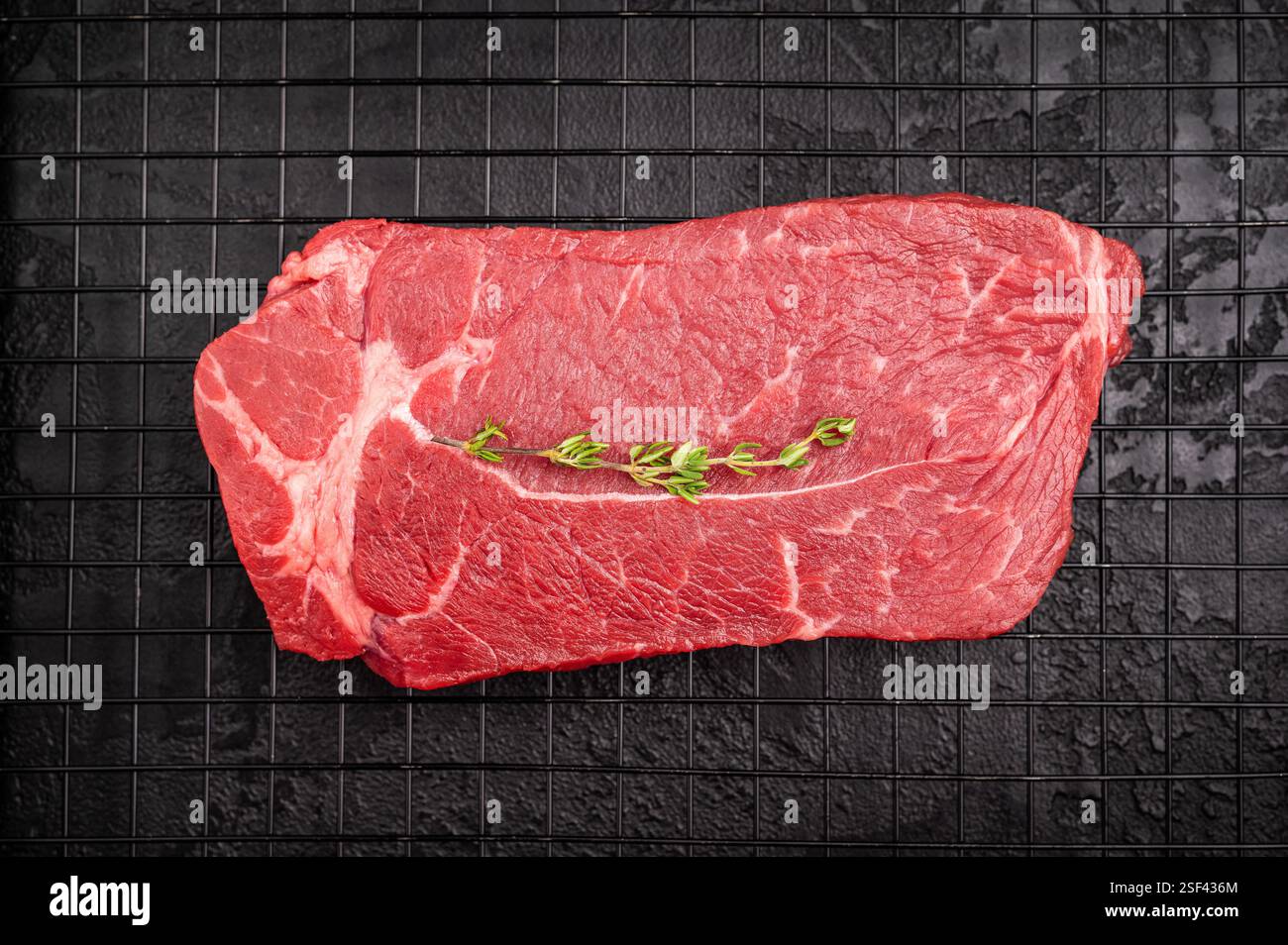 Sirloin Rack Raw top sirloin beef steak with thyme on a rack. black background. top ...