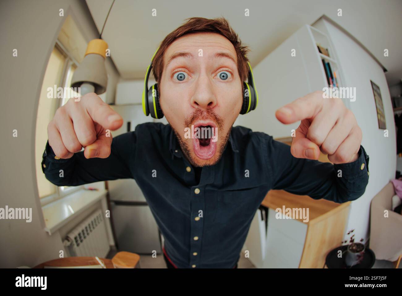 Portrait of handsome young man in headphones listen music have fun and point at you Stock Photo