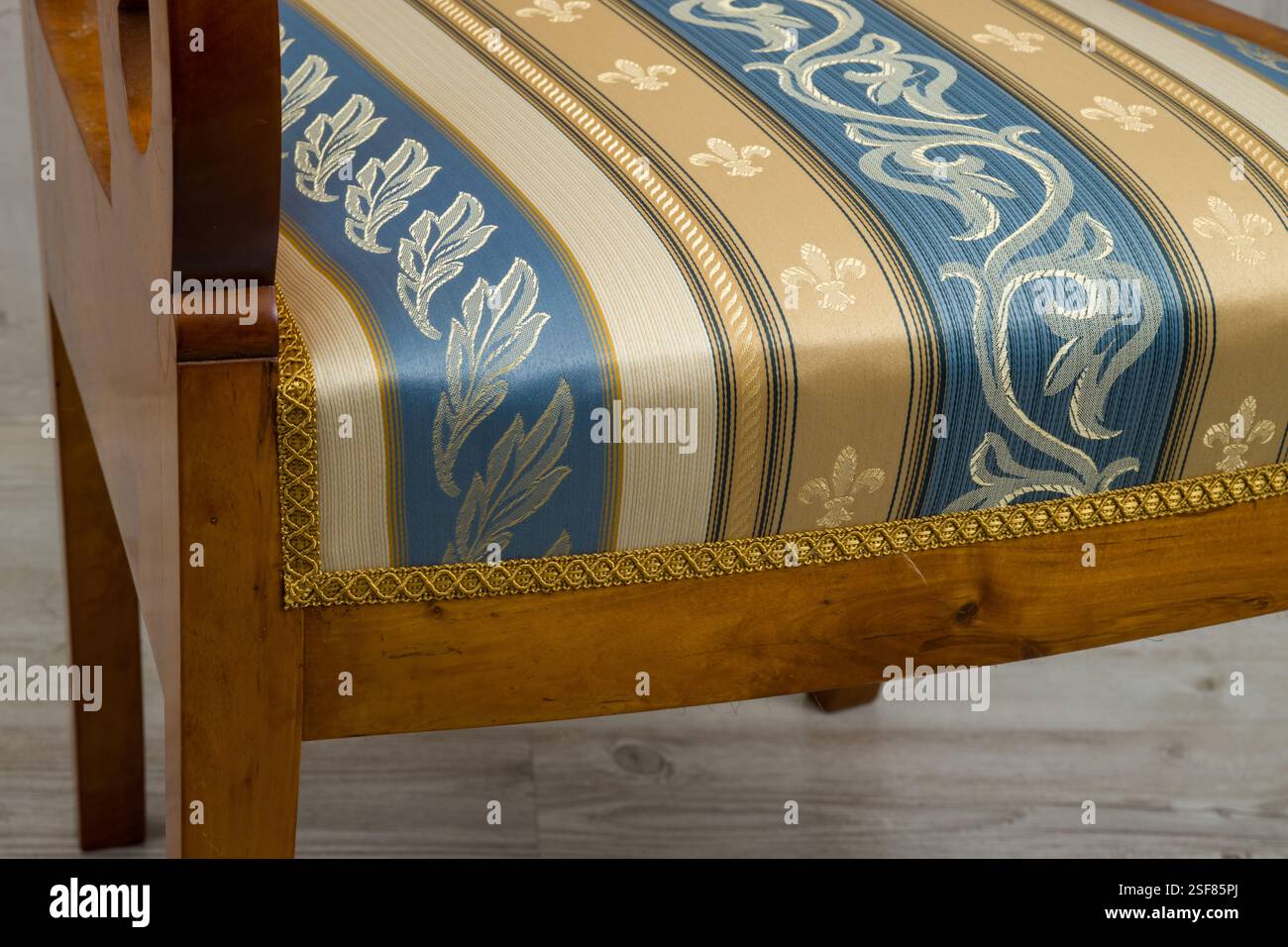 Biedermeier-style armchair in a room setting with a textured wall and ...
