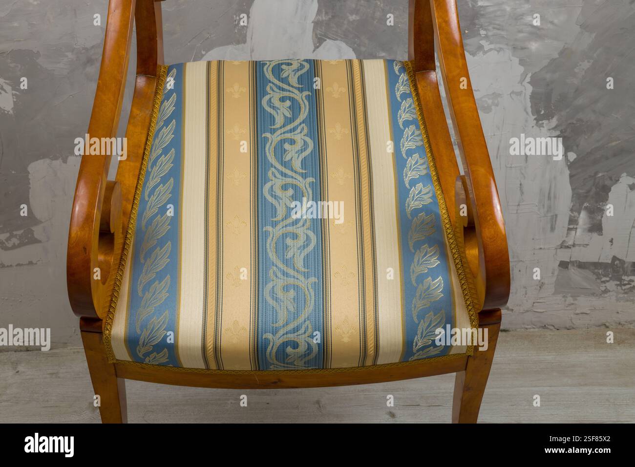 Biedermeier-style armchair in a room setting with a textured wall and ...