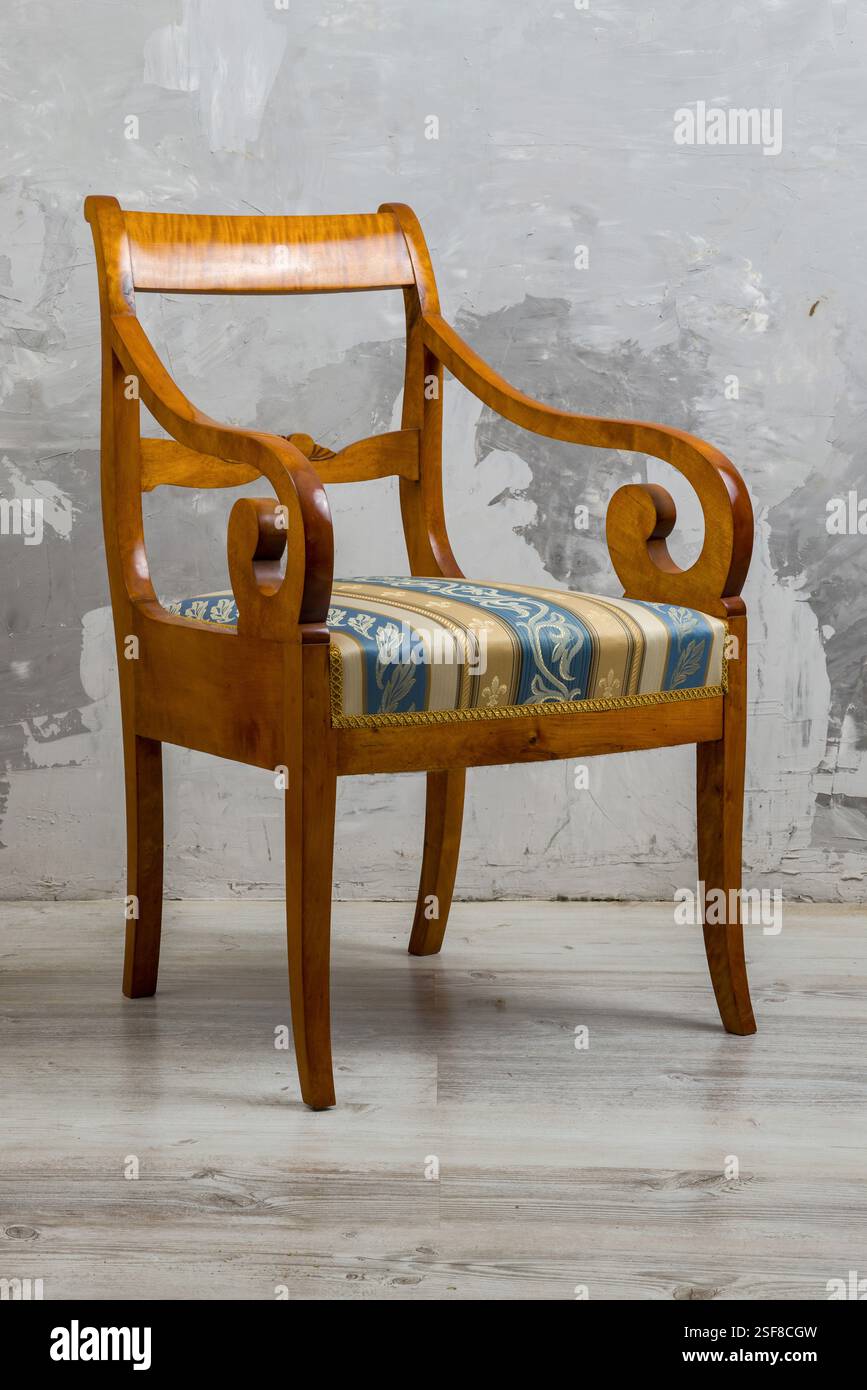 Biedermeier-style armchair in a room setting with a textured wall and ...