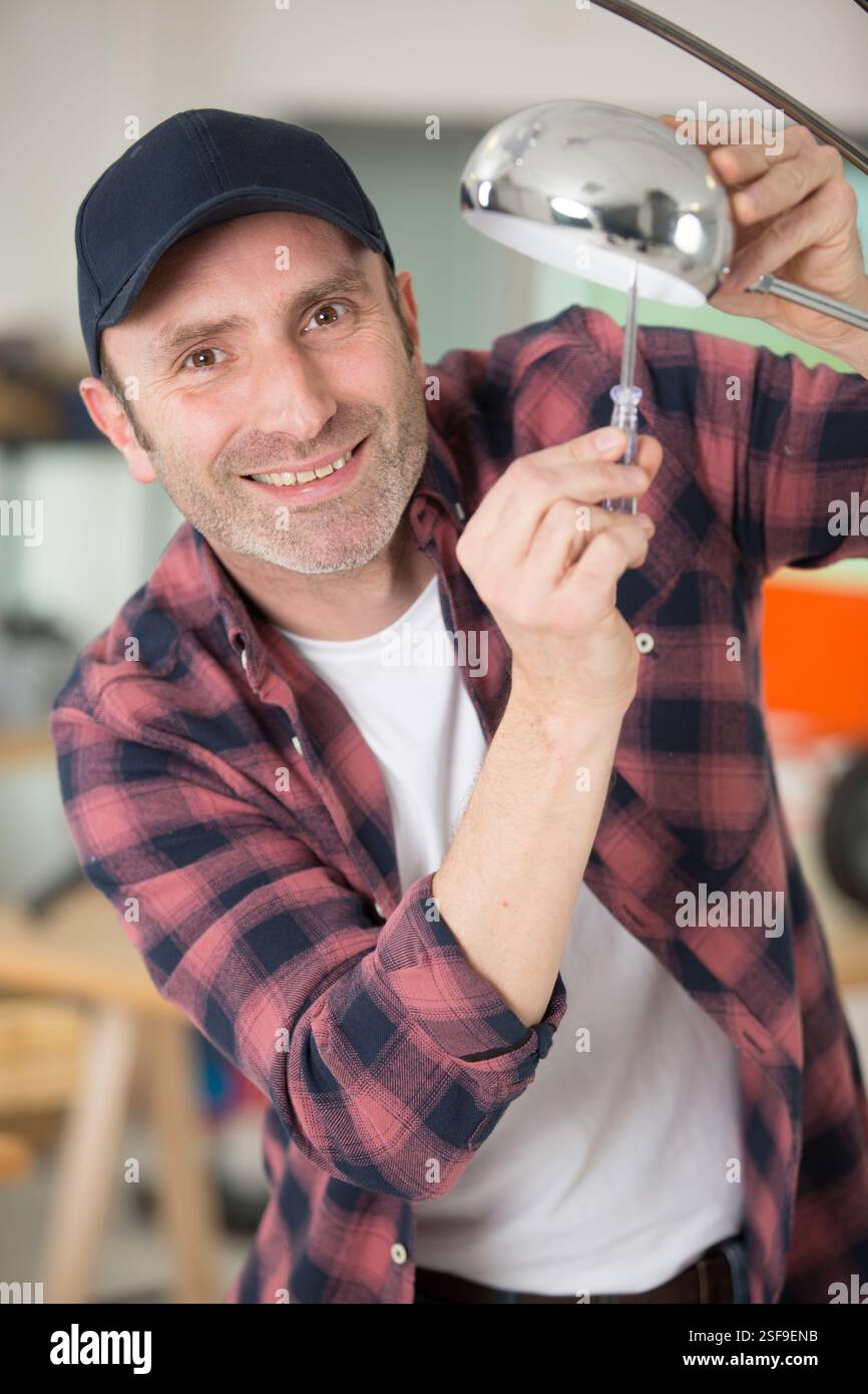 man using screwriver on decorative lamp Stock Photo