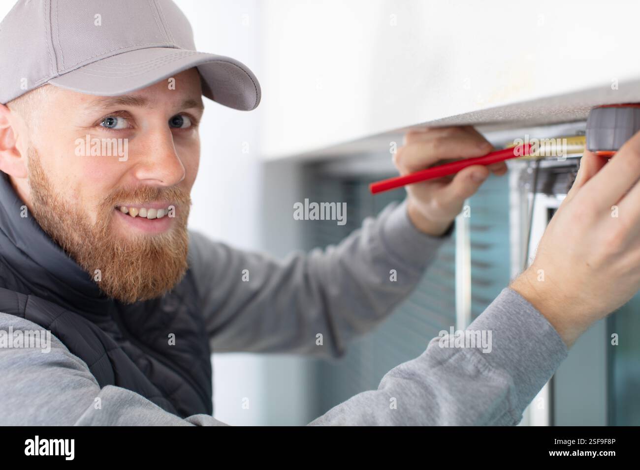 service man installing window with screwdriver Stock Photo