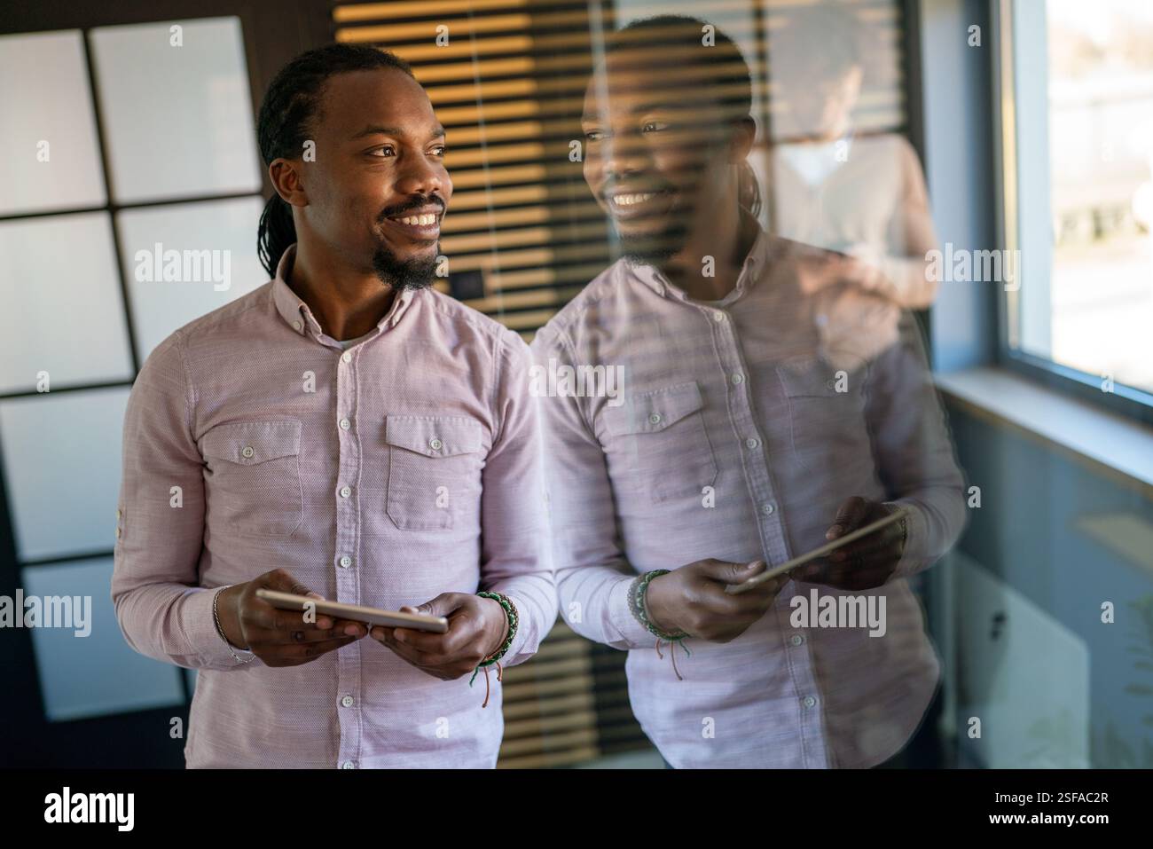 Relaxed smiling african american man holding digital tablet computer using apps Stock Photo