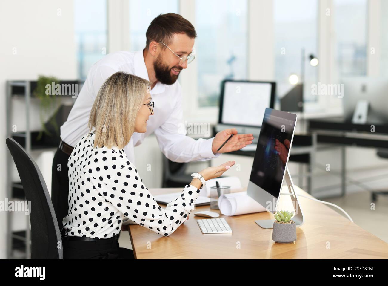 Technicians making digital engineering drawing on computer at desk in office Stock Photo
