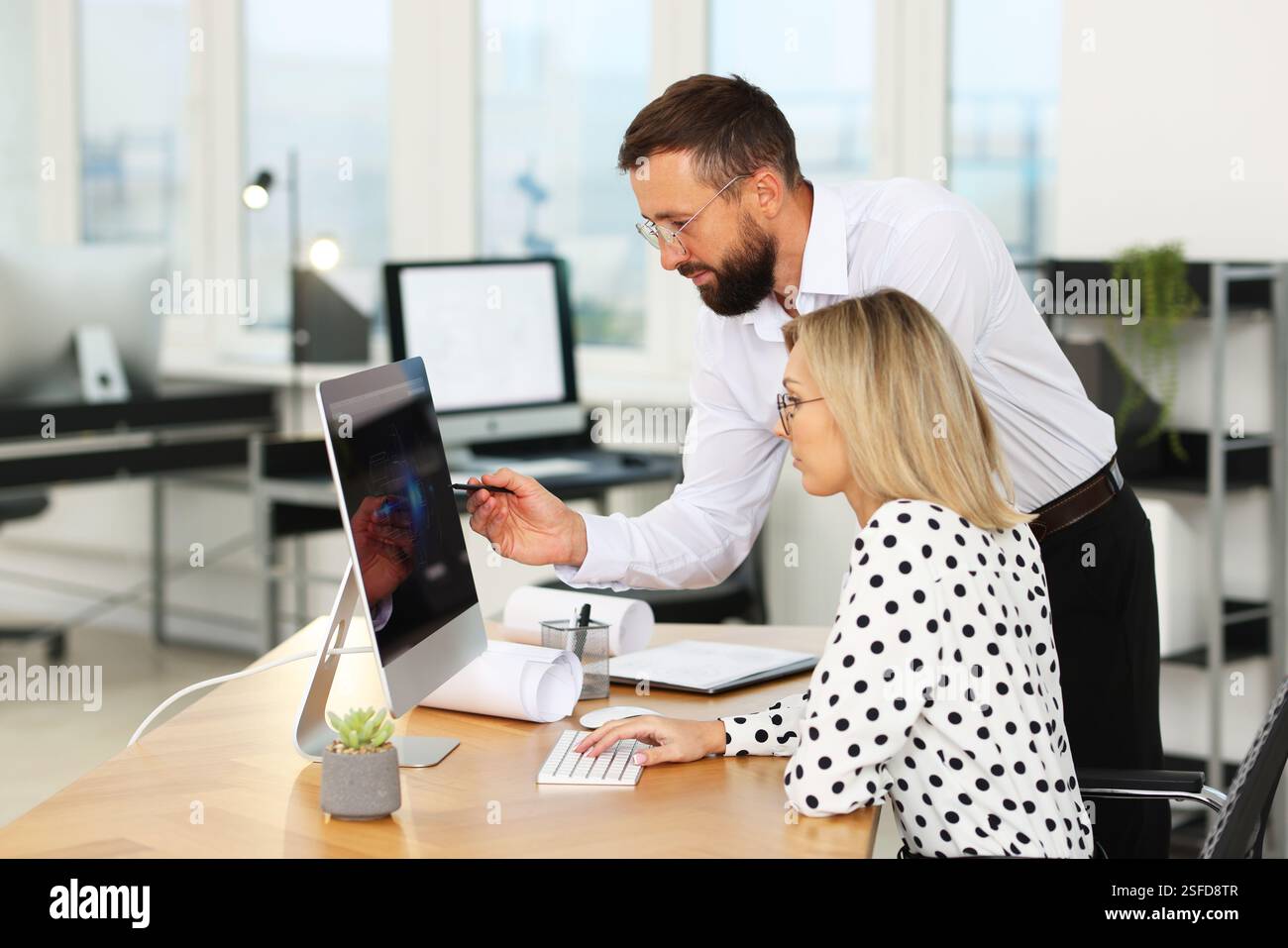 Technicians making digital engineering drawing on computer at desk in office Stock Photo
