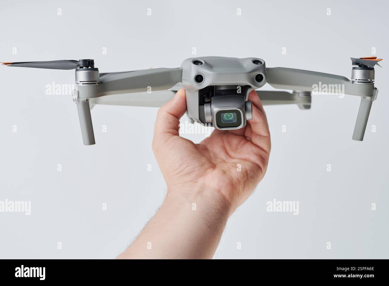 Hand hold small drone on white studio background Stock Photo