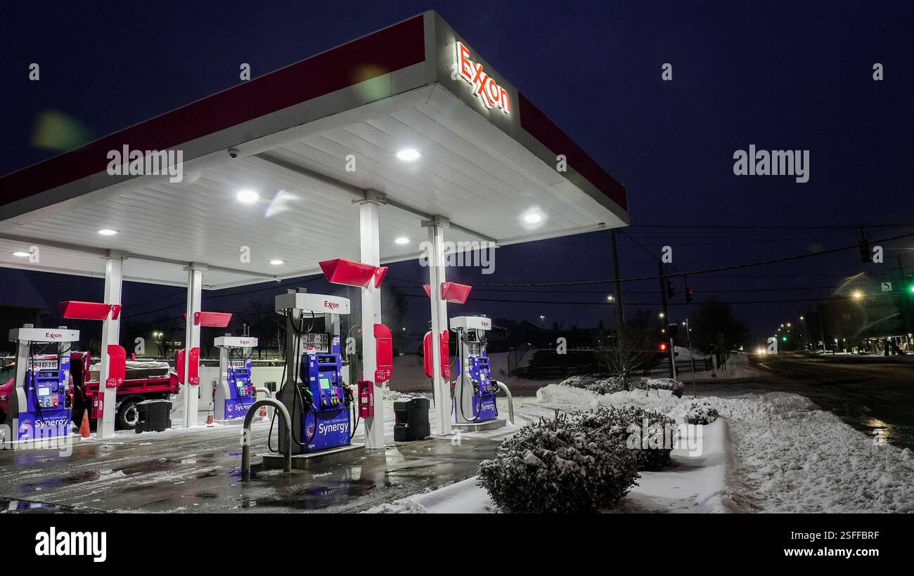 NORWALK, CT, USA - FEBRUARY 9, 2025: Snow covers the ground as a gas station remains brightly lit at night, serving travelers and locals in the area. Stock Photo