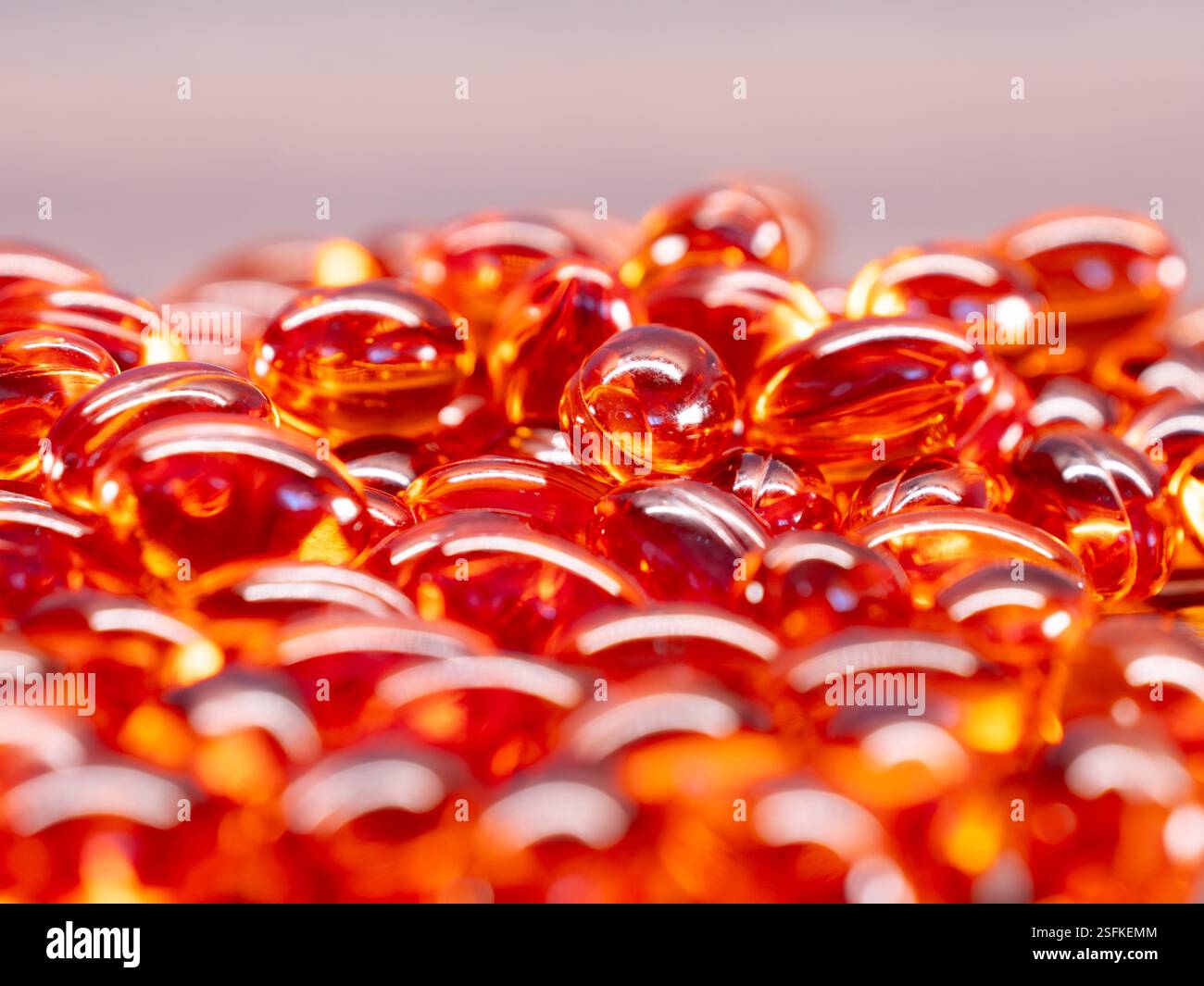 Omega 3 transparent red pills, fish oil for health with blurred foreground and background Stock Photo