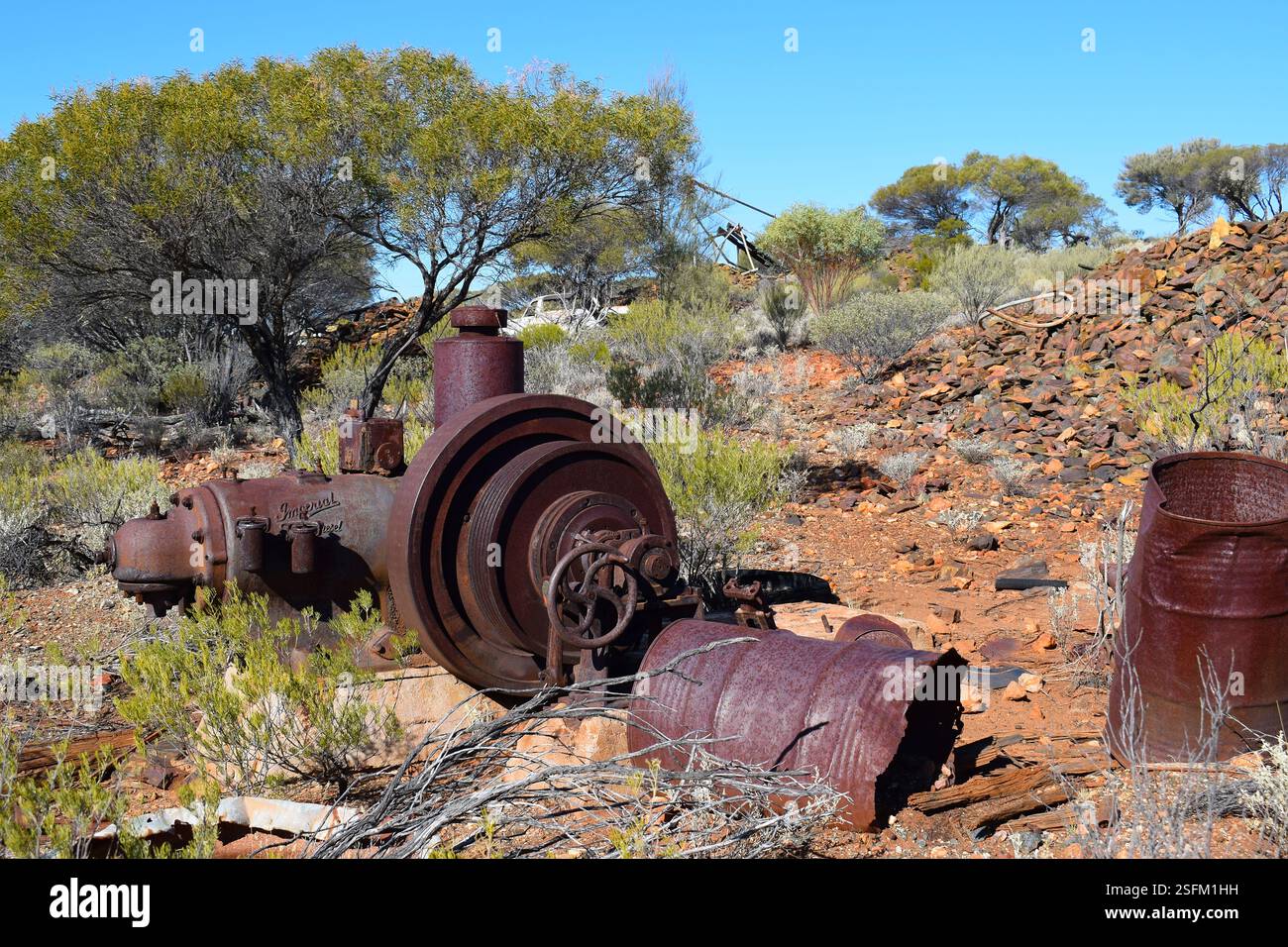 A rusted pulley engine left behind in the desert near Kalgoorlie, Western Australia, once used in the region's historic gold mines. Stock Photo