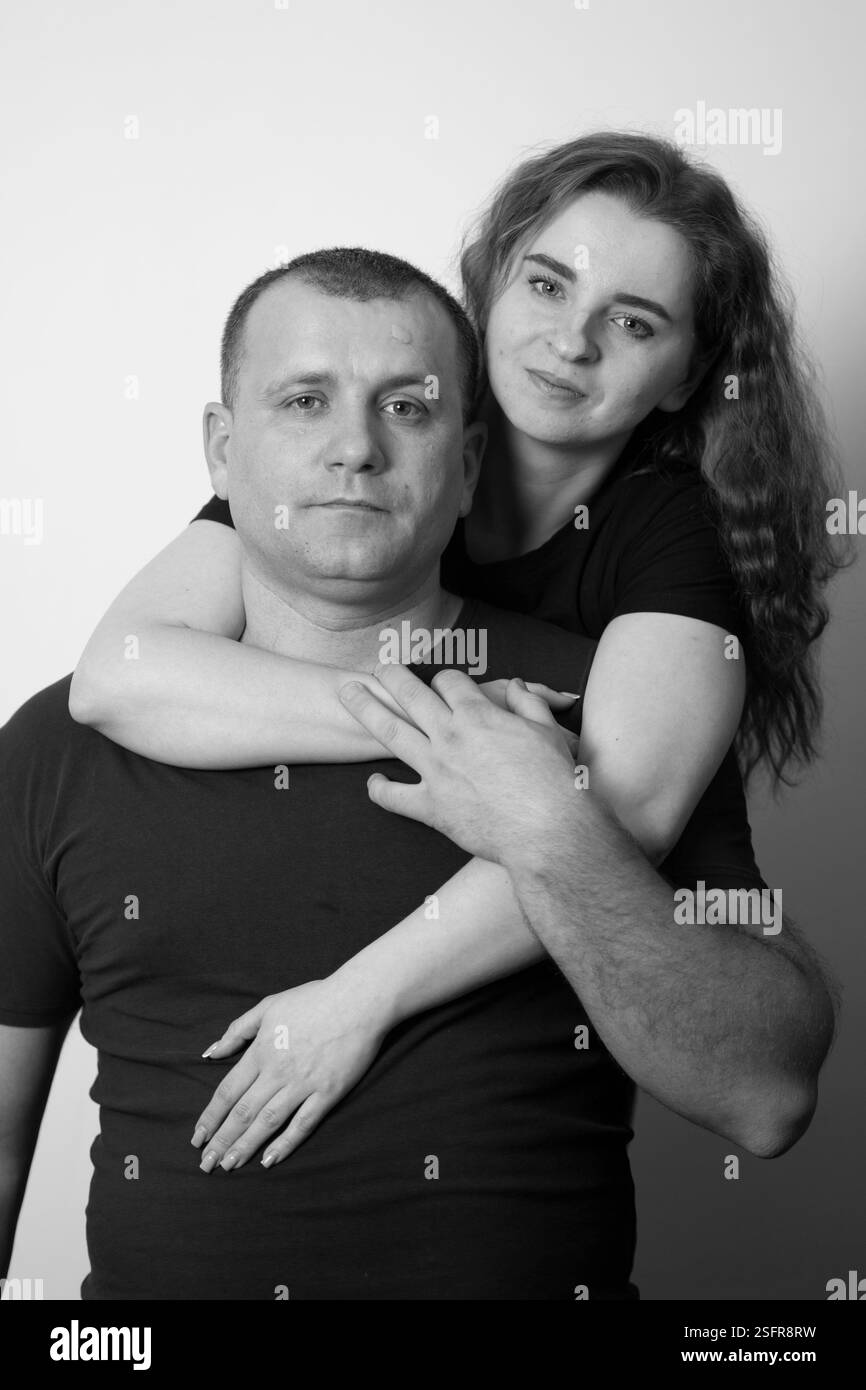 Young couple sharing a tender embrace in a monochrome setting Stock Photo