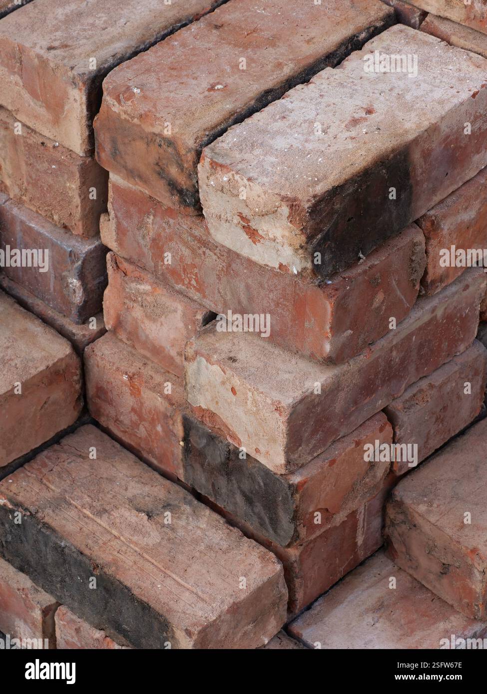 An isometric stack of various reclaimed house bricks Stock Photo