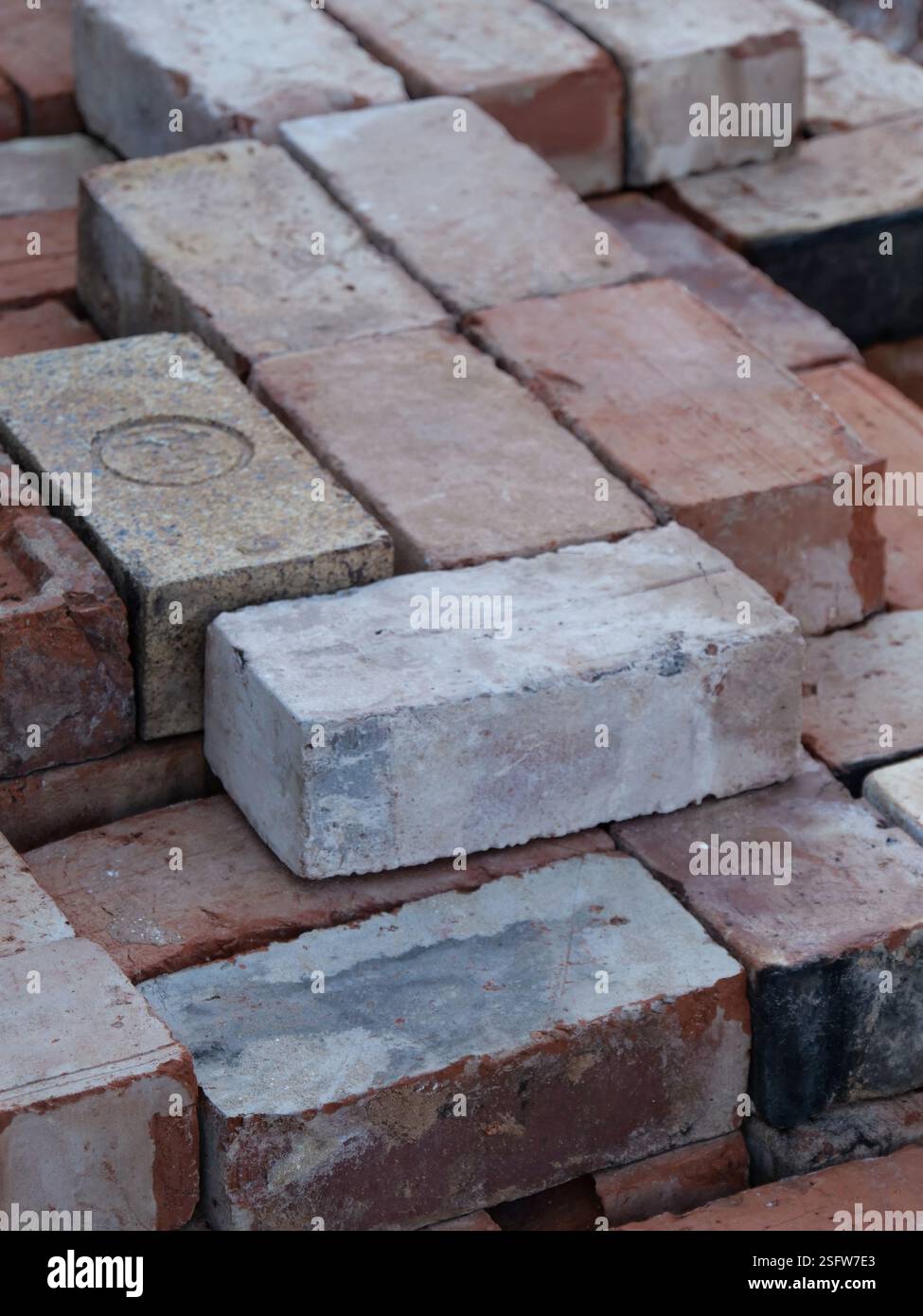 An isometric stack of various reclaimed house bricks Stock Photo